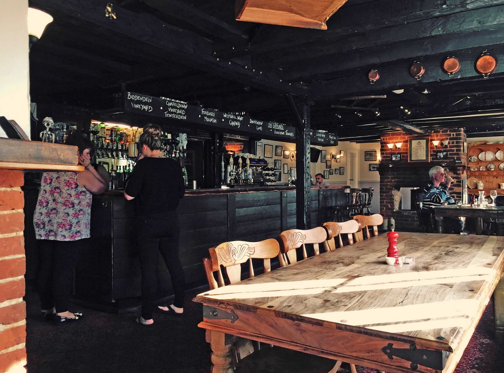 Interior of a traditional Kent country pub with timber beams and warm lighting